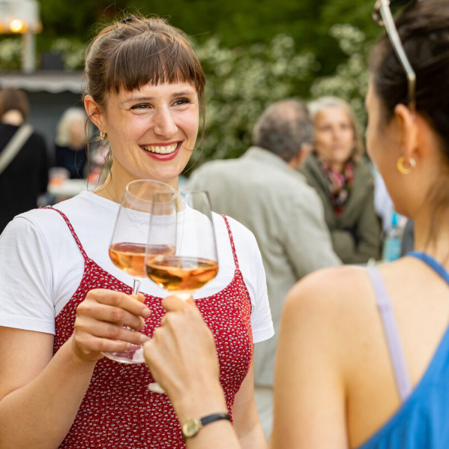 zwei Frauen stoßen mit Wein an