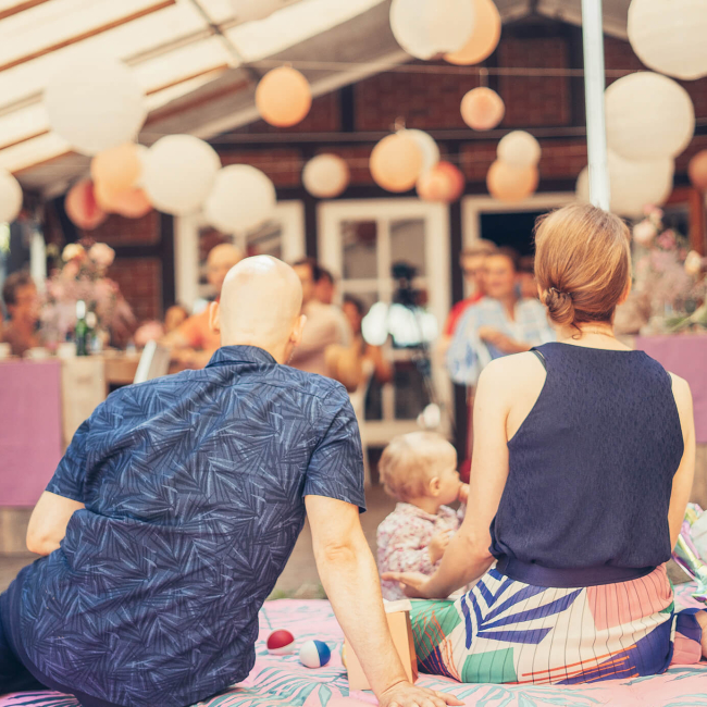 Familie sitzt auf einer Decke während und genießt ein Event