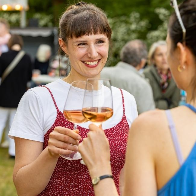 Gäste stoßen mit Wein an