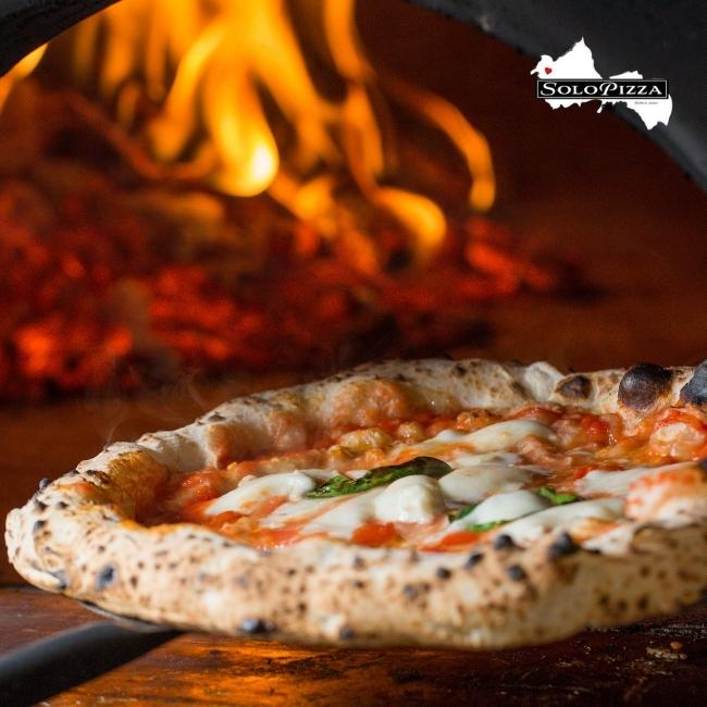 Steinofenpizza vor dem Pizzaofen