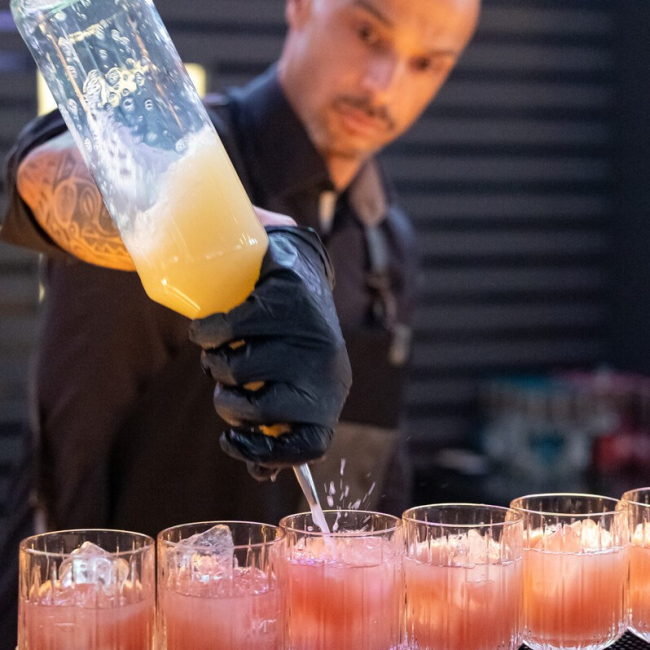 Barkeeper gießt Chocktail ein für Catering Drinks